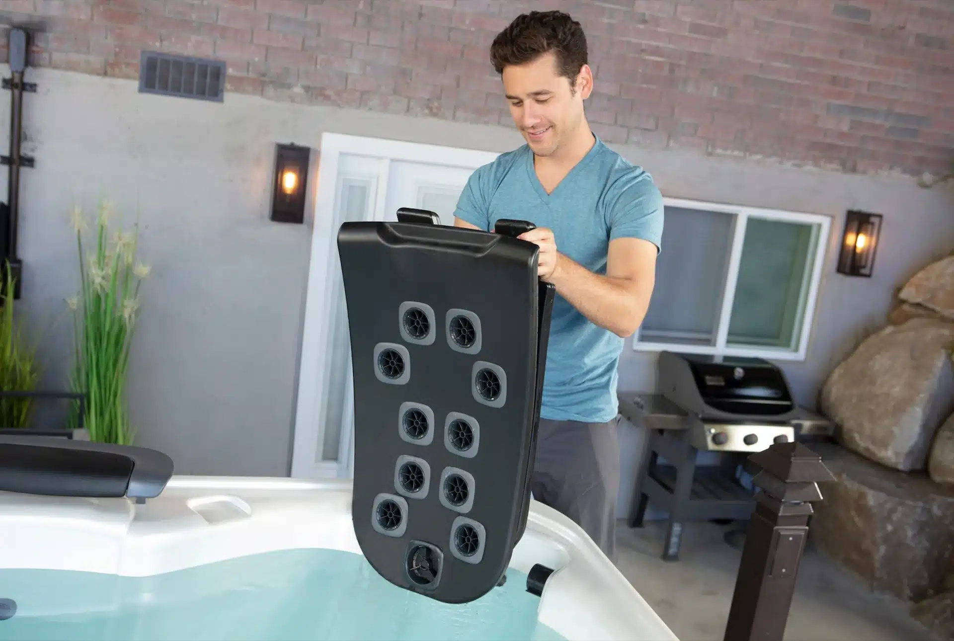 A hot tub owner removes a JetPak Therapy System module, complete with a unique configuration of hot tub jets, from the corner seat of a Bullfrog Spa.