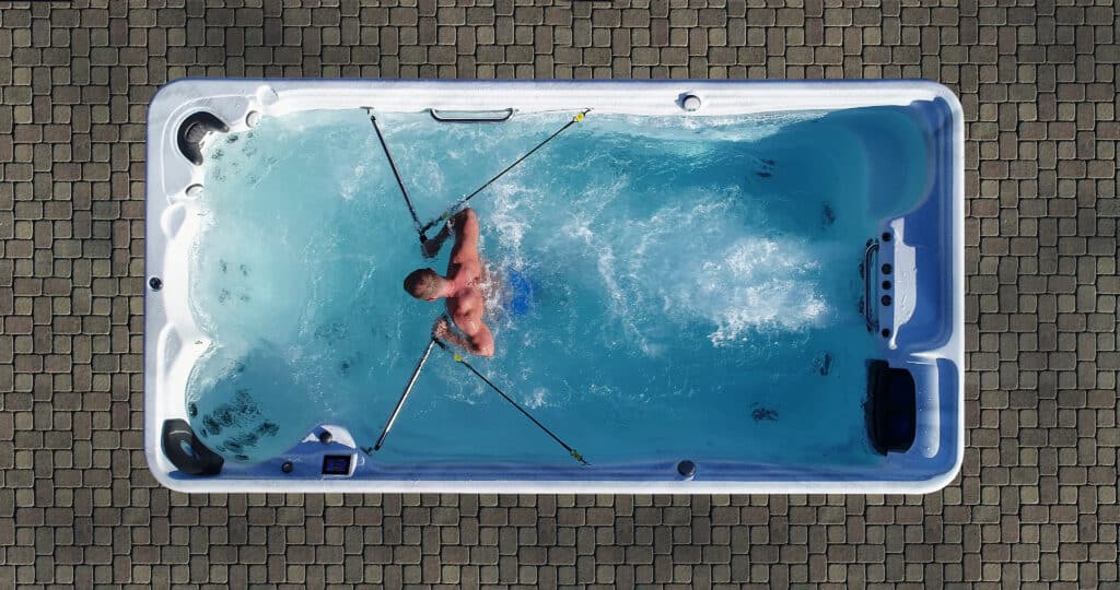 a man exercising in a swim spa with a row kit