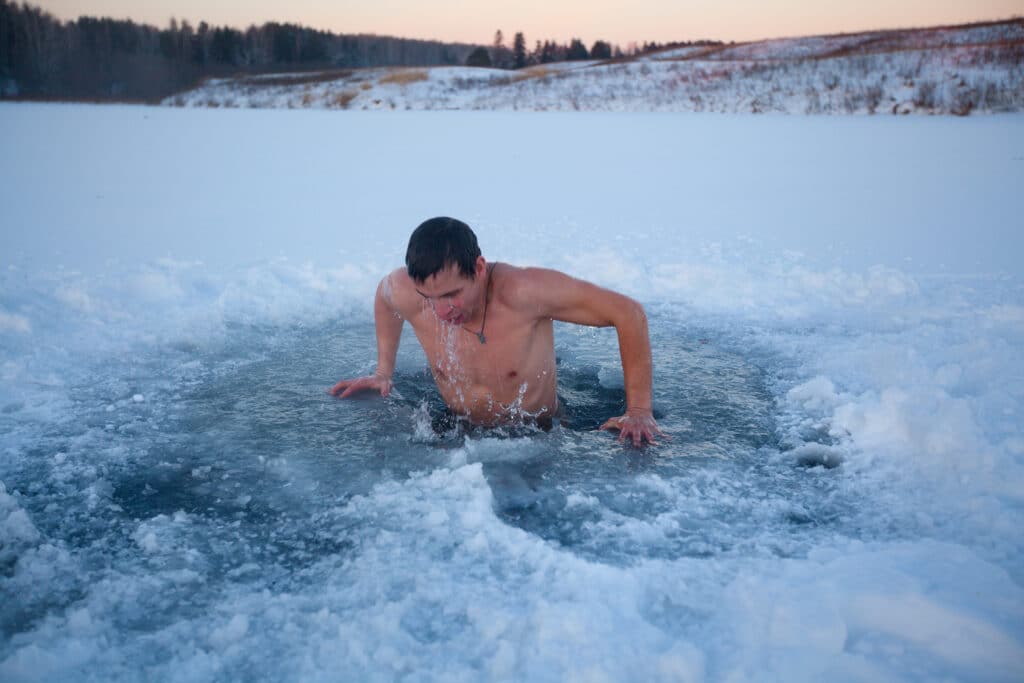 man doing a cold plunge pool in winter
