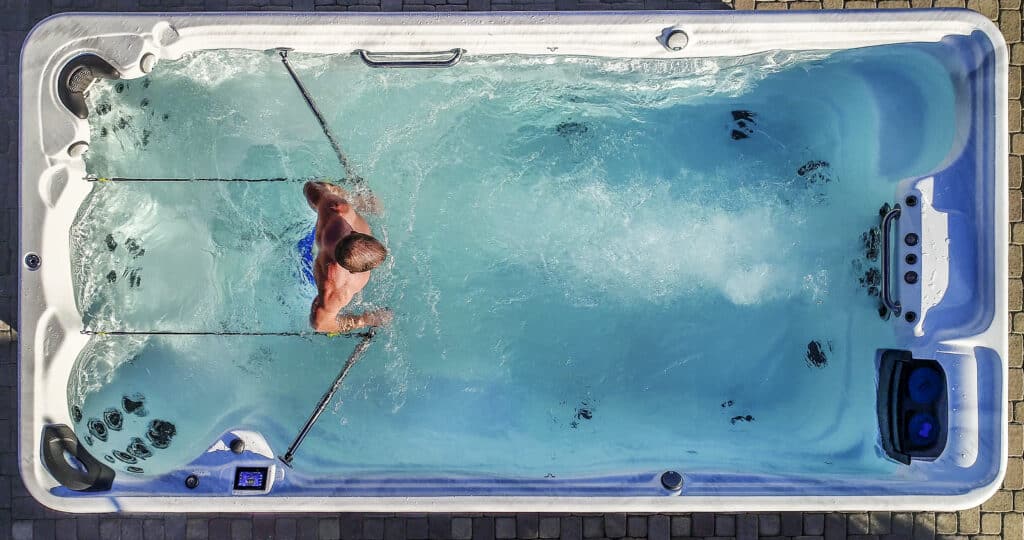 male athlete doing a swim spa fitness routine in a swim spa