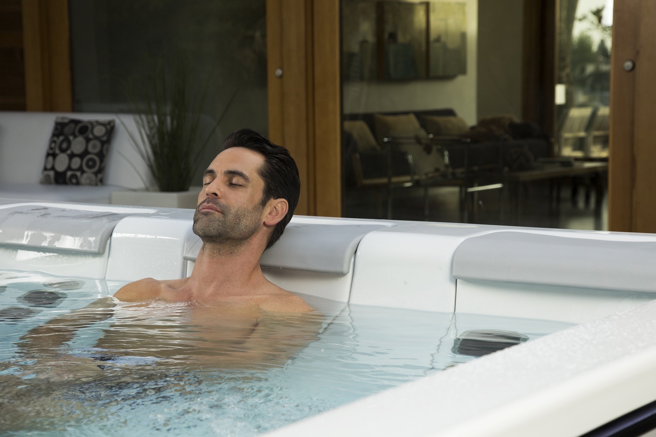 man soaks in a hot tub after an ice bath