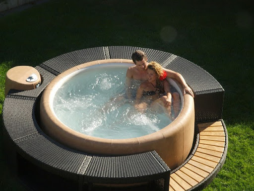 A couple enjoying soaking in a Softub spa for hot tub health benefits.
